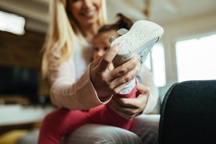 closeup-mother-helping-her-small-daughter-put-her-shoes-home_637285-2915.jpg