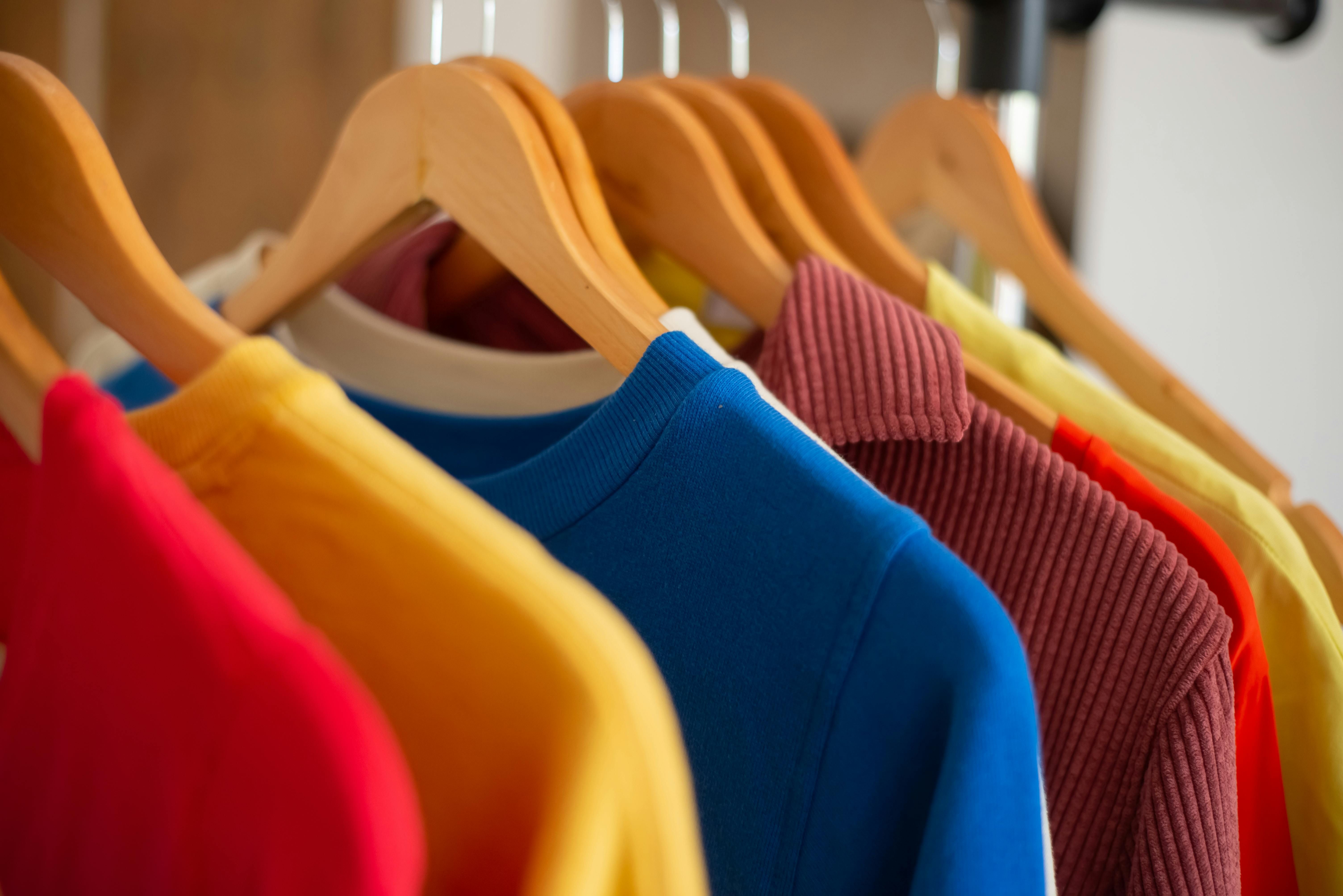 Colourful outfits on a dress rack 